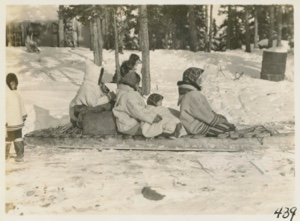 Image of Eskimo [Inuit] family on sledge ready to leave station.